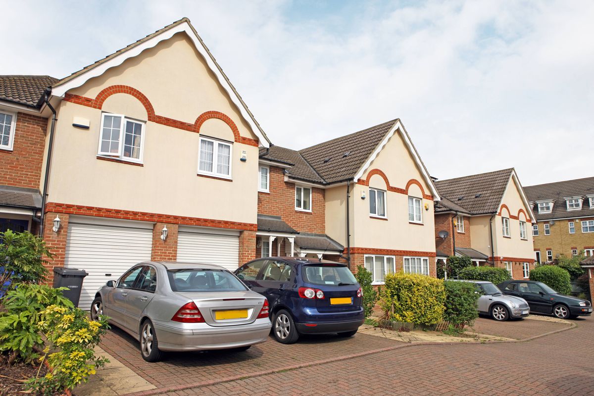 Newly built homes with cars parked on driveways.