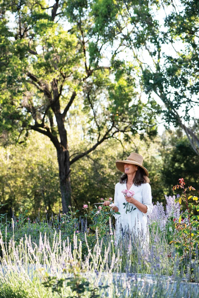 Mickey Robertson wearing a floppy hat while tending to her garden
