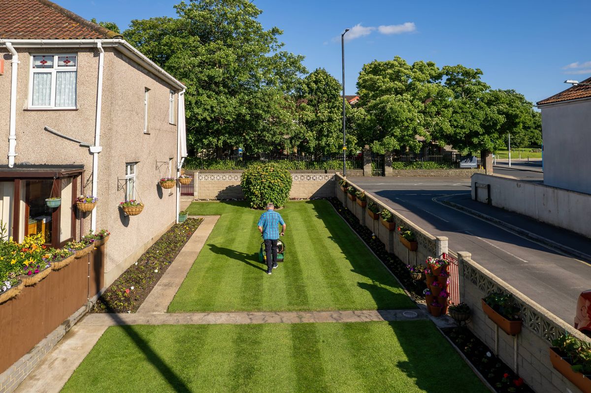 BRISTOL, UK - 08th June 2024 - Senior English couple gardening during a sunny day at a residential home in urban Bristol suburb,