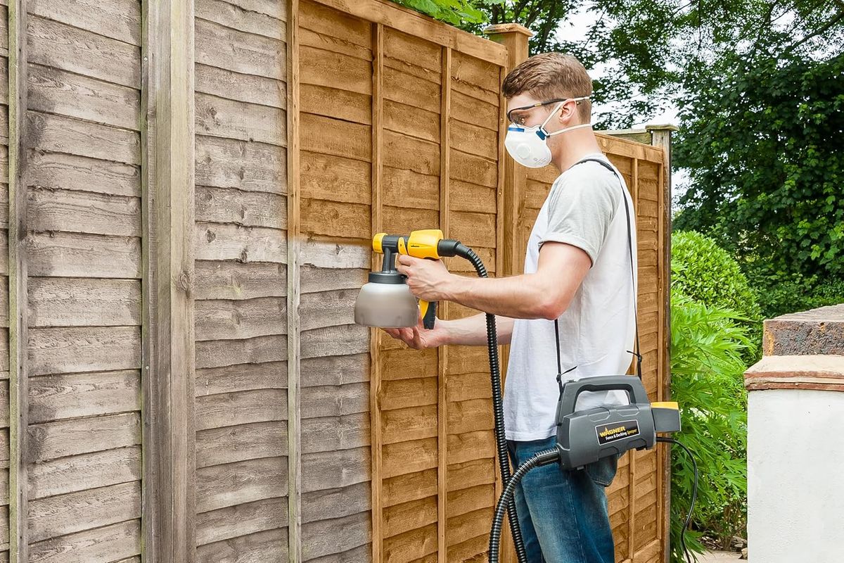 A man using the Wagner Fence & Decking Paint Sprayer
