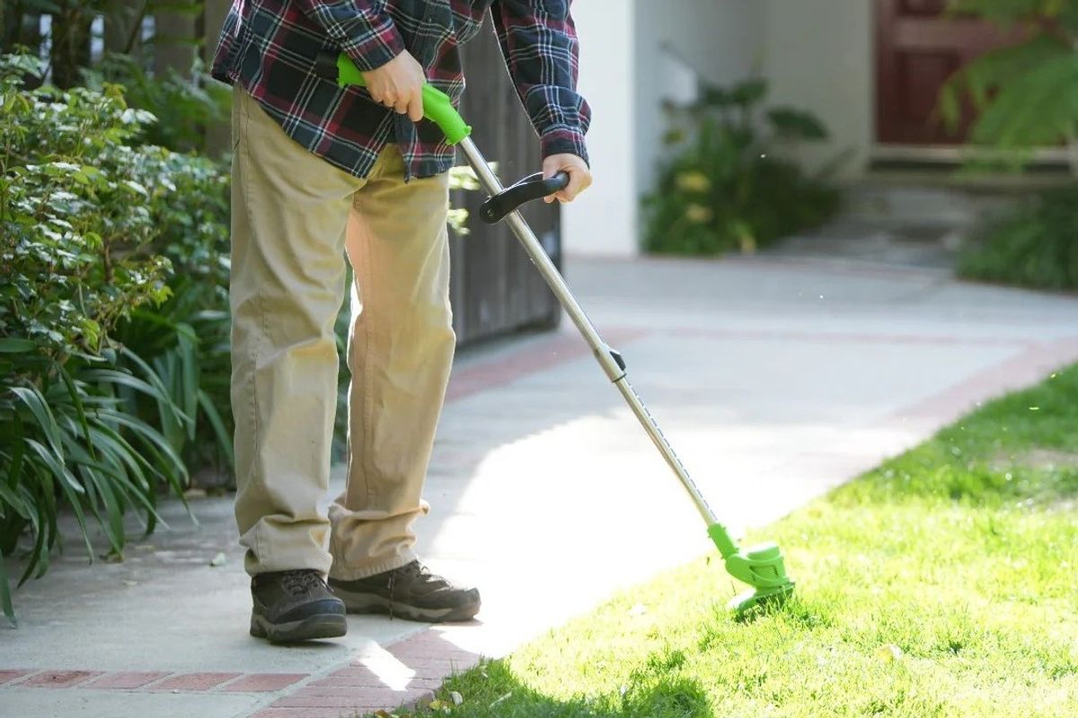 A man using the Drew&Cole Lawn Barber