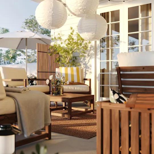 A garden with a white and hardwood scheme featuring IKEA storage boxes, screens and chairs