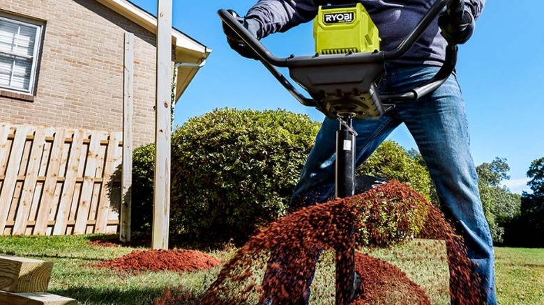 Person making a hole with a 40V HP Brushless Earth Auger Powerhead with 8-inch Bit