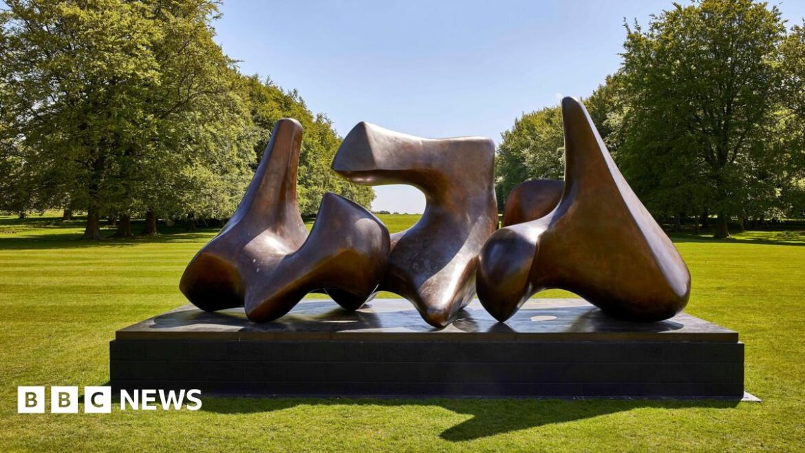 Henry Moore work to be displayed at Kew Gardens and Wakehurst Large curved bronze sculpture by Henry Moore on a plinth, surrounded by open grass and trees in bright sunlight
