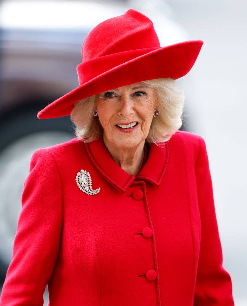 Queen Camilla in bright red coat dress and hat shoulders up