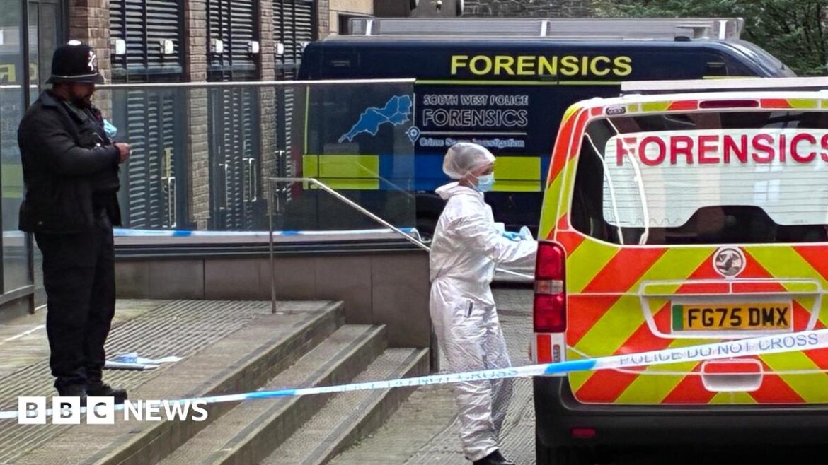 Death of man found in Bristol rooftop garden ‘suspicious’ A police cordon around the steps of a large block of flats. A police officer in a helmet stands at the door. A forensics specialist in a white haz-mat suit opens the door of a van. Two vans marked forensics are parked at the foot of the steps to the building.