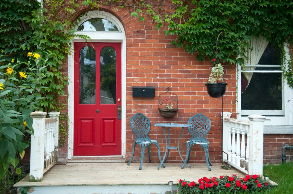 Red outside door with a patio and seating Red outside door with a patio and seating