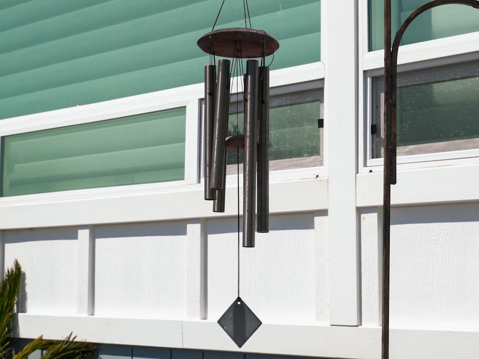 black wind chimes hanging behind someone's house