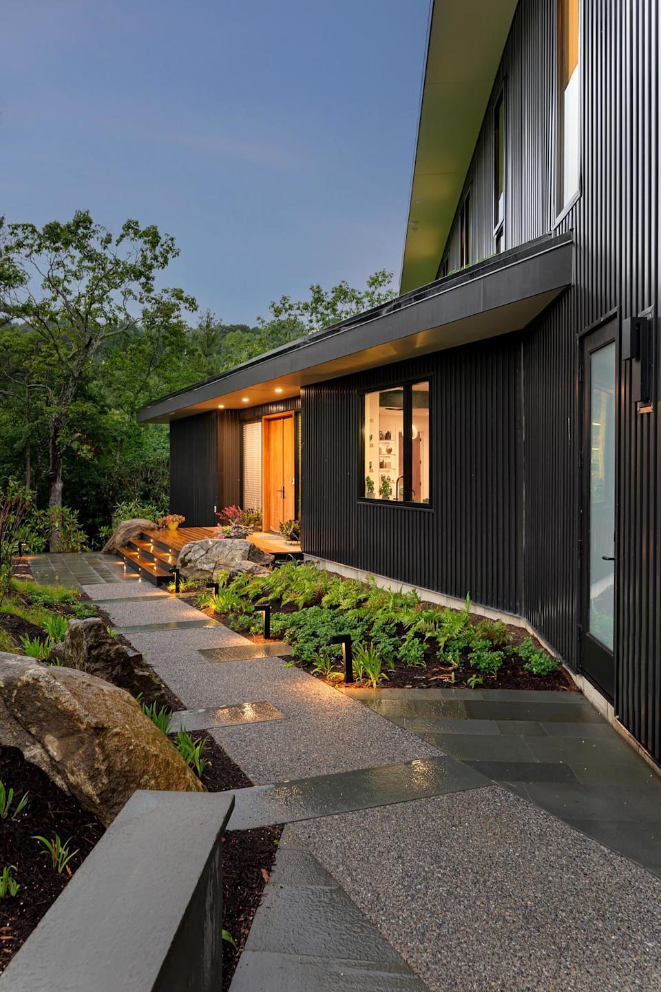 A garden path with spotlights and lighting illuminating the porch area
