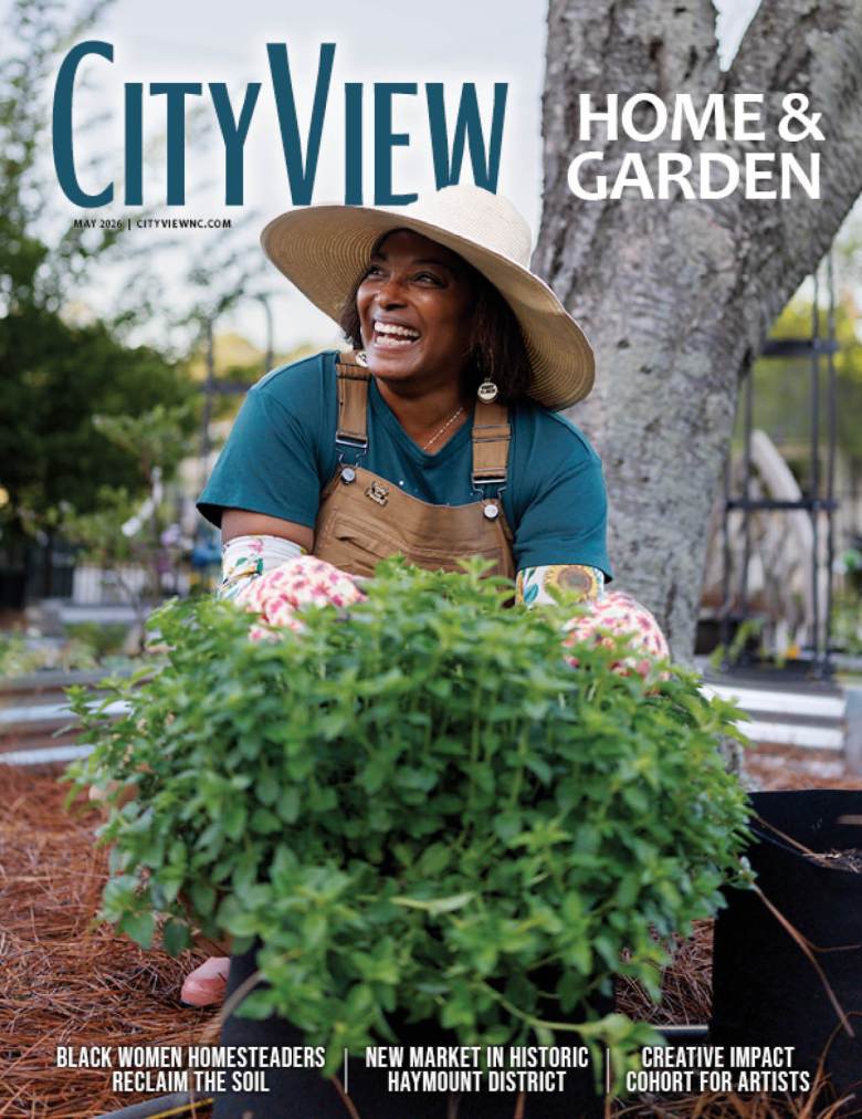 A Black woman planting in her garden looks to the left while smiling widely.