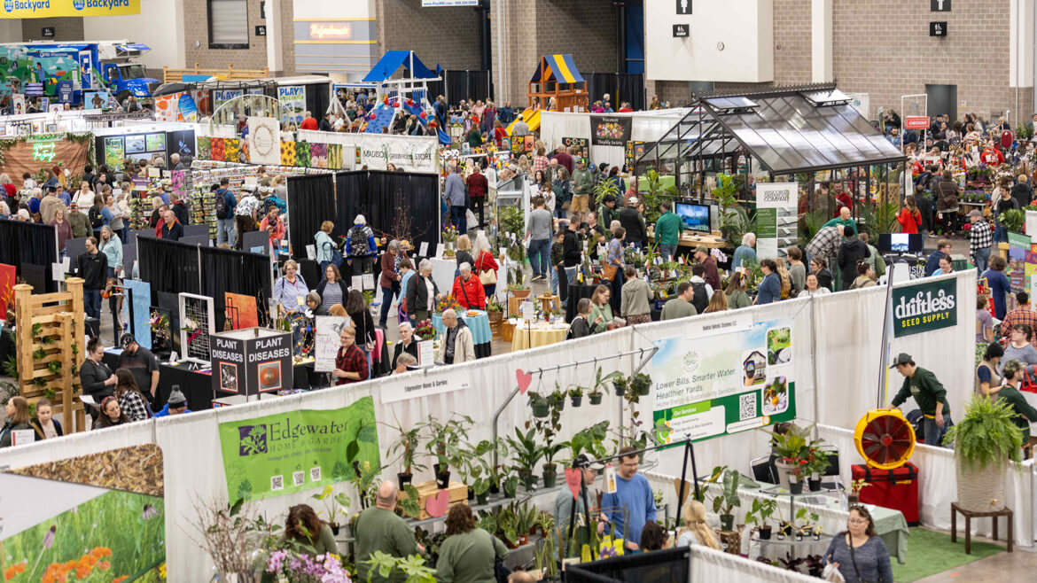Garden & Green Living Expo 2027 Aerial view of a crowded indoor garden and home expo, with dozens of vendor booths displaying plants, flowers, and gardening products. Visible exhibitors include Edgewater Home & Garden, Driftless Seed Supply, Madison Greenhouse Store, and a home energy sustainability services booth. Attendees browse the packed convention hall floor.
