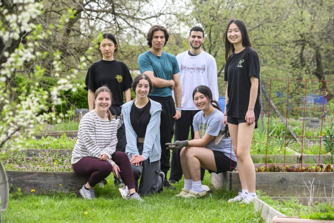 Seven college students pose for a group photo in the Blue Jay's Perch Community Garden.