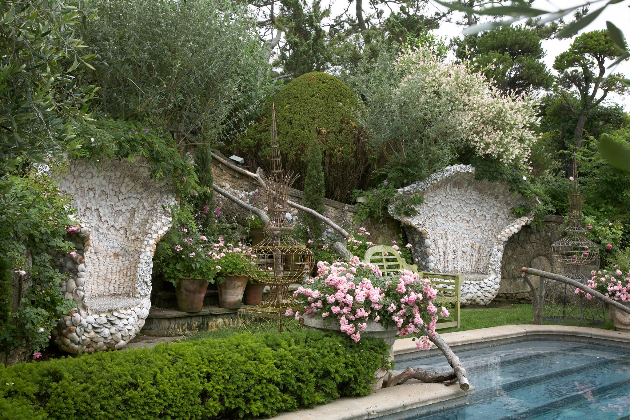 VER080117_106 Seashell chairs flank entrance to pool in a garden