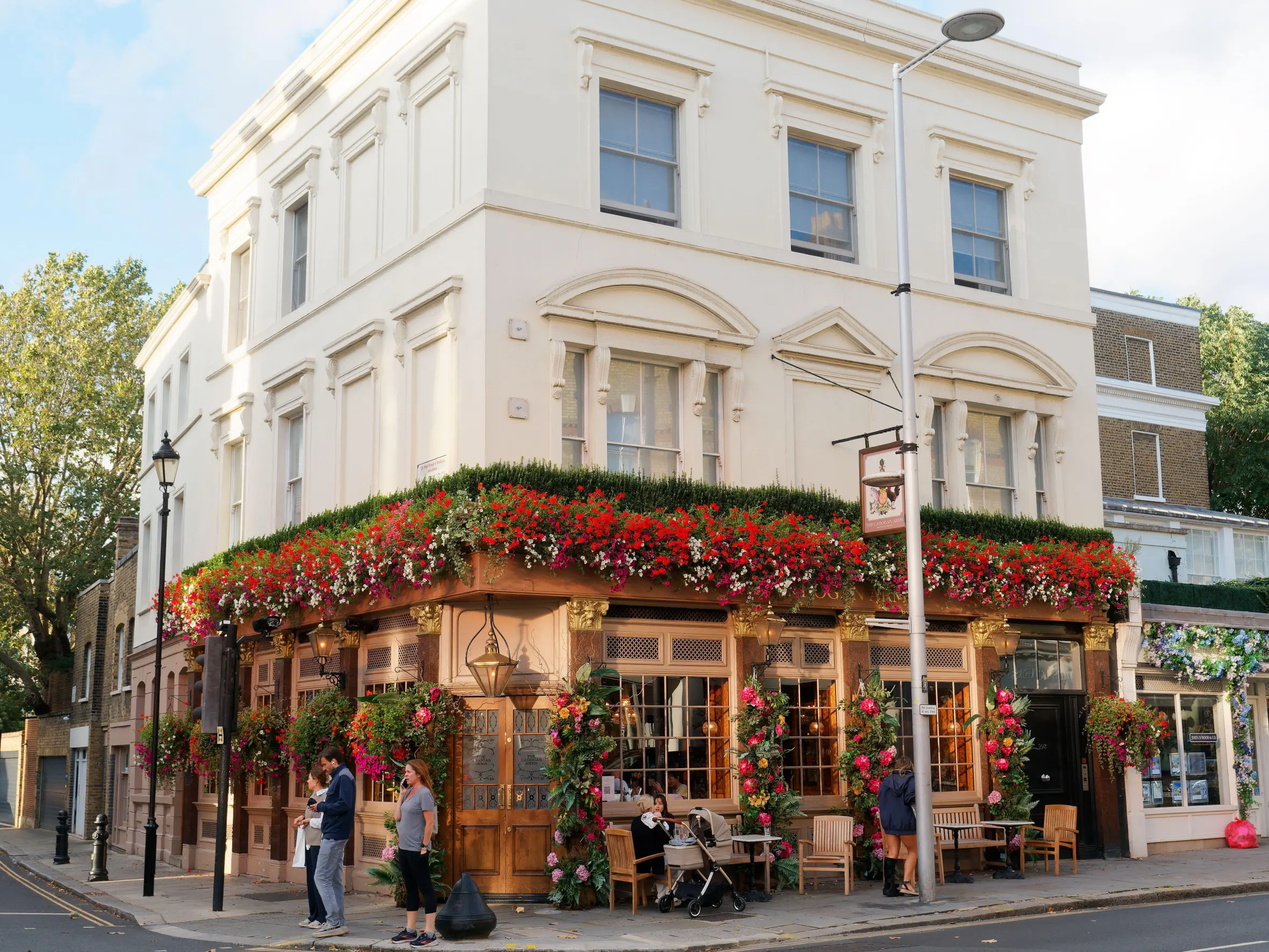 The Cadogan Arms pub in Chelsea, London, adorned with red and white flowers on its facade.