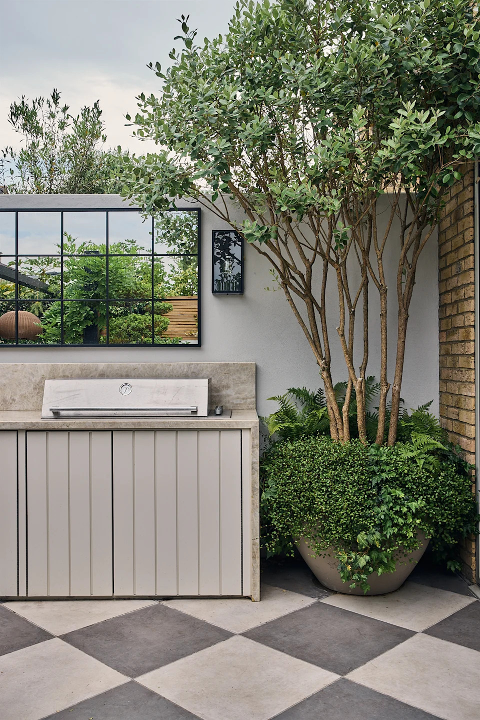 a modern garden filled with plants with a large checkerboard floor