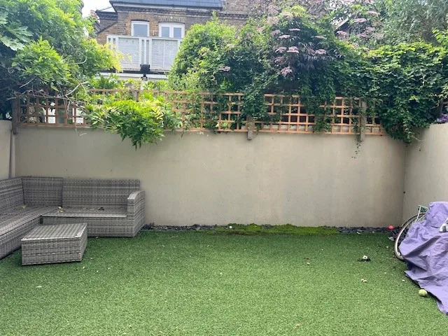 a modern garden filled with plants with a large checkerboard floor