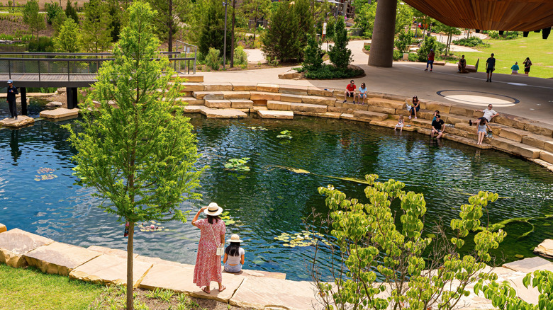 Mother and daughter wearing hats enjoying a spring afternoon beside a pond at Downtown Cary Park, North Carolina