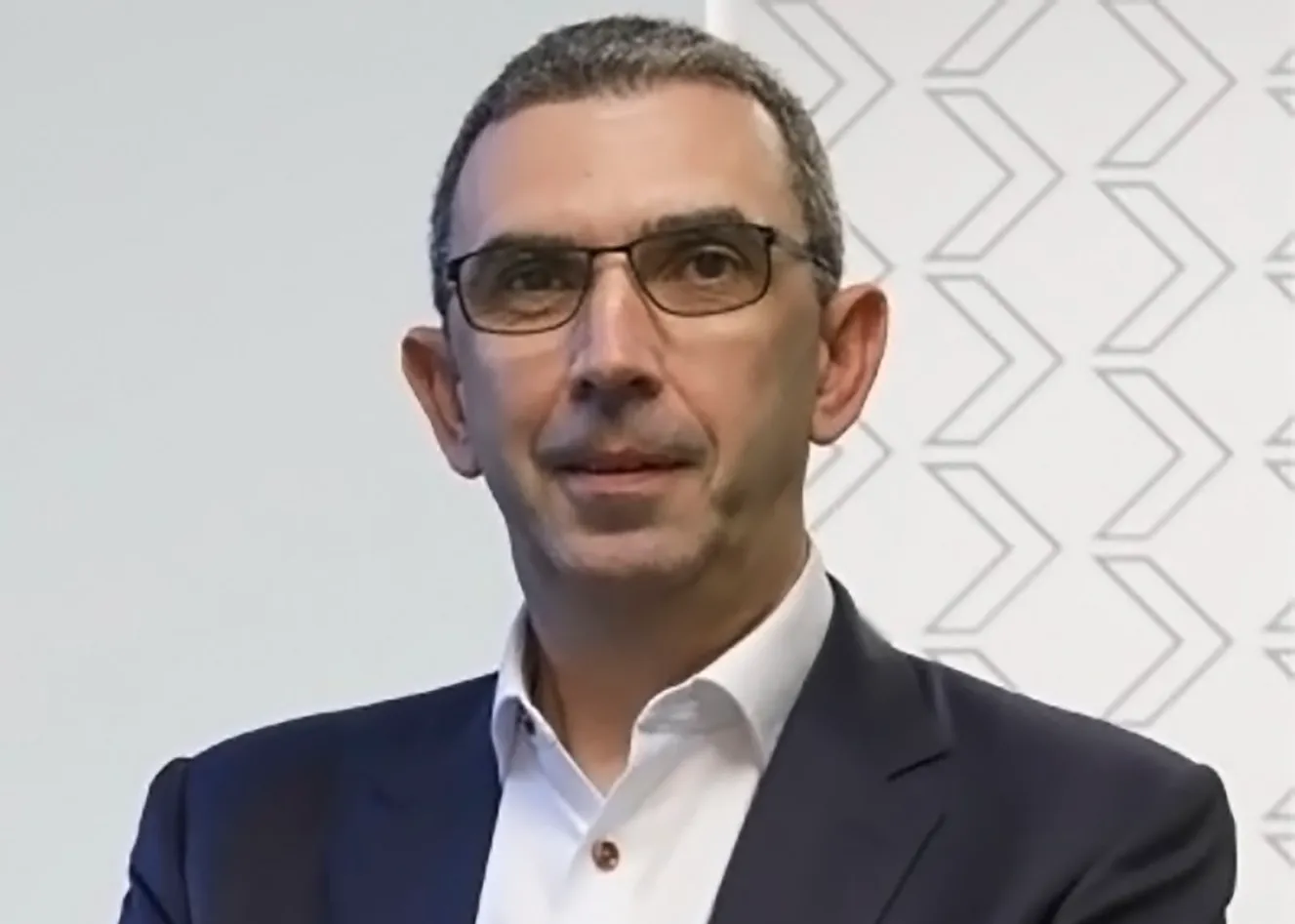 Padraic Bermingham, Partner at Strata Financial, wearing glasses and a suit, with his arms crossed.