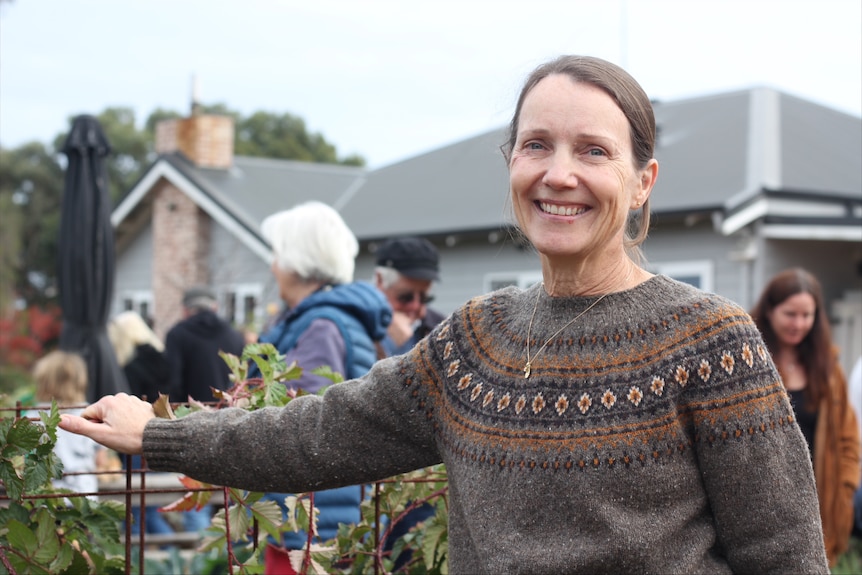 A woman in a fair isle jumper in a garden