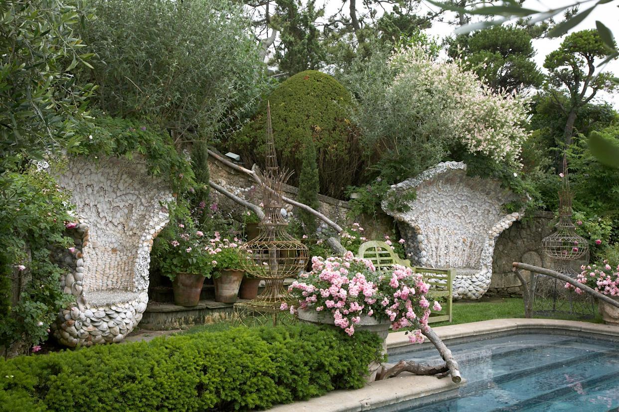 Seashell chairs flank entrance to pool in a garden
