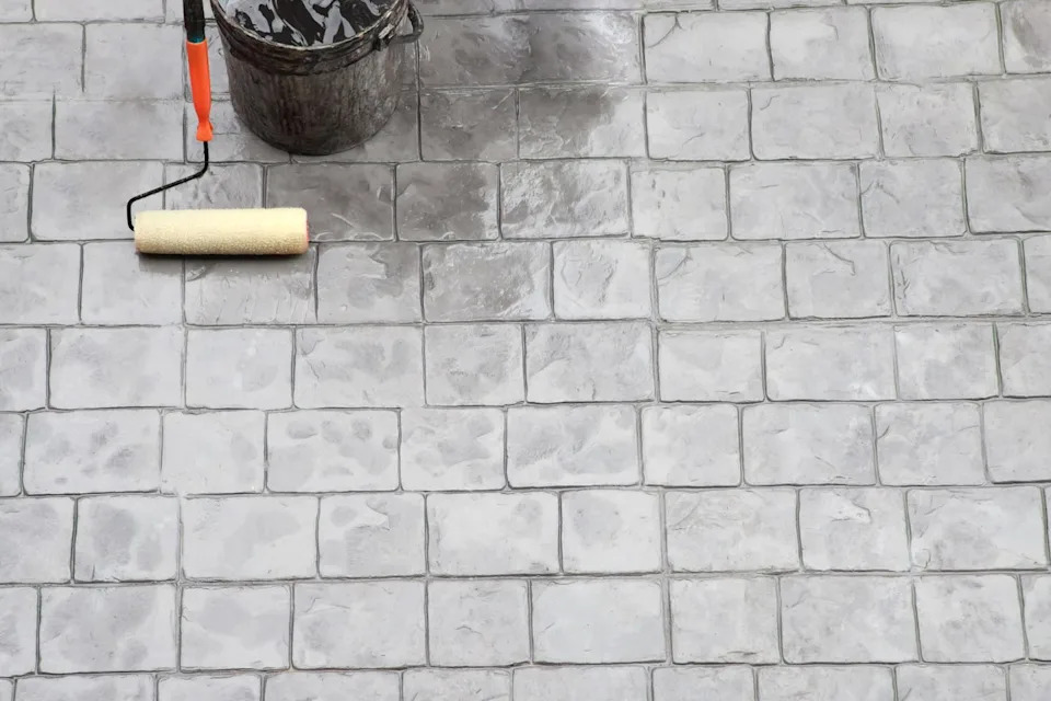 workers are applying waterproofing with a brush. the roof system of a high rise building
