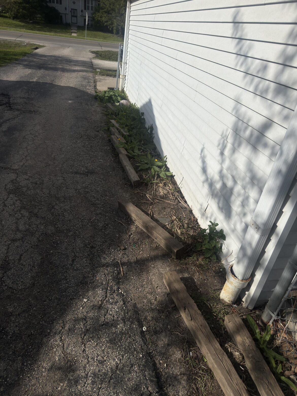 I have this random spot on the side of my house. What can I line it with instead of this wood that were here when I moved in?