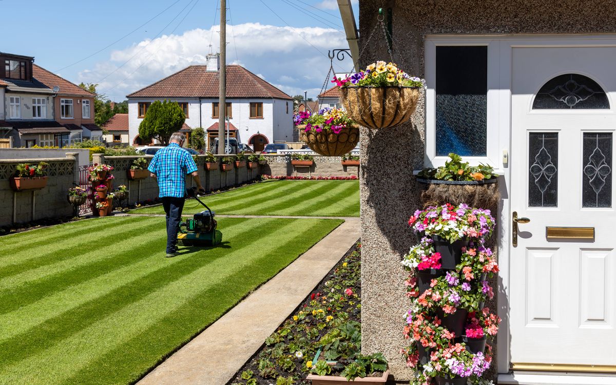 BRISTOL, UK - 16th June 2024 - Senior English couple gardening during a sunny day at a residential home in urban Bristol suburb, England, United Kingdom, Europe