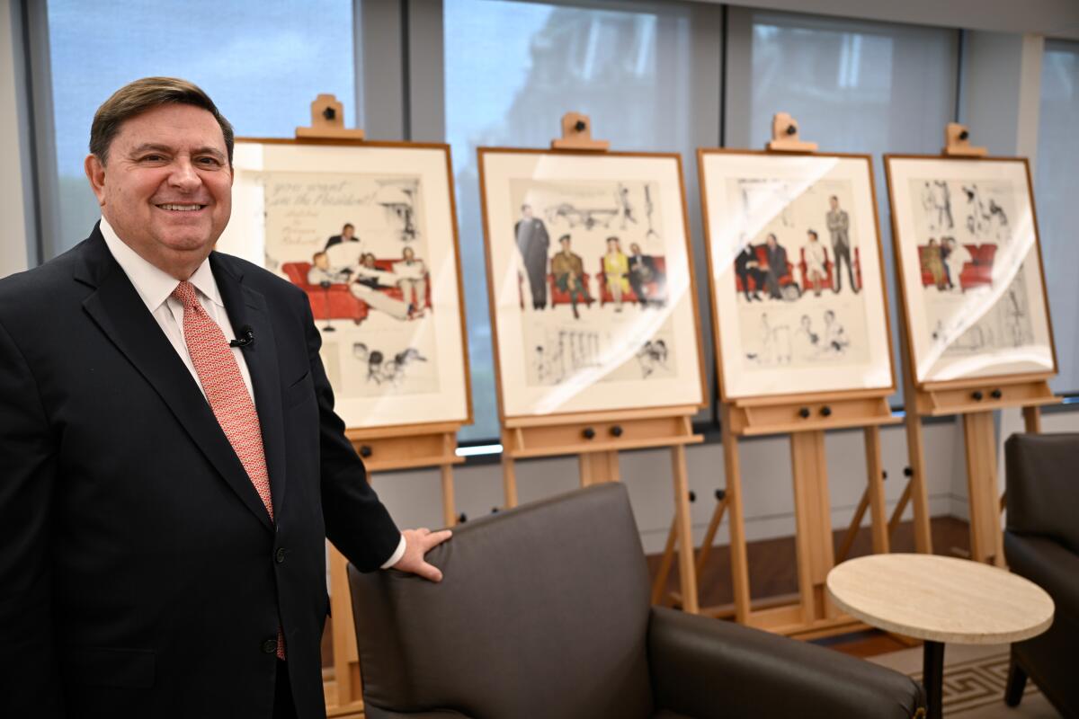 Stewart McLaurin, president of the White House Historical Association with four paintings by Norman Rockwell.