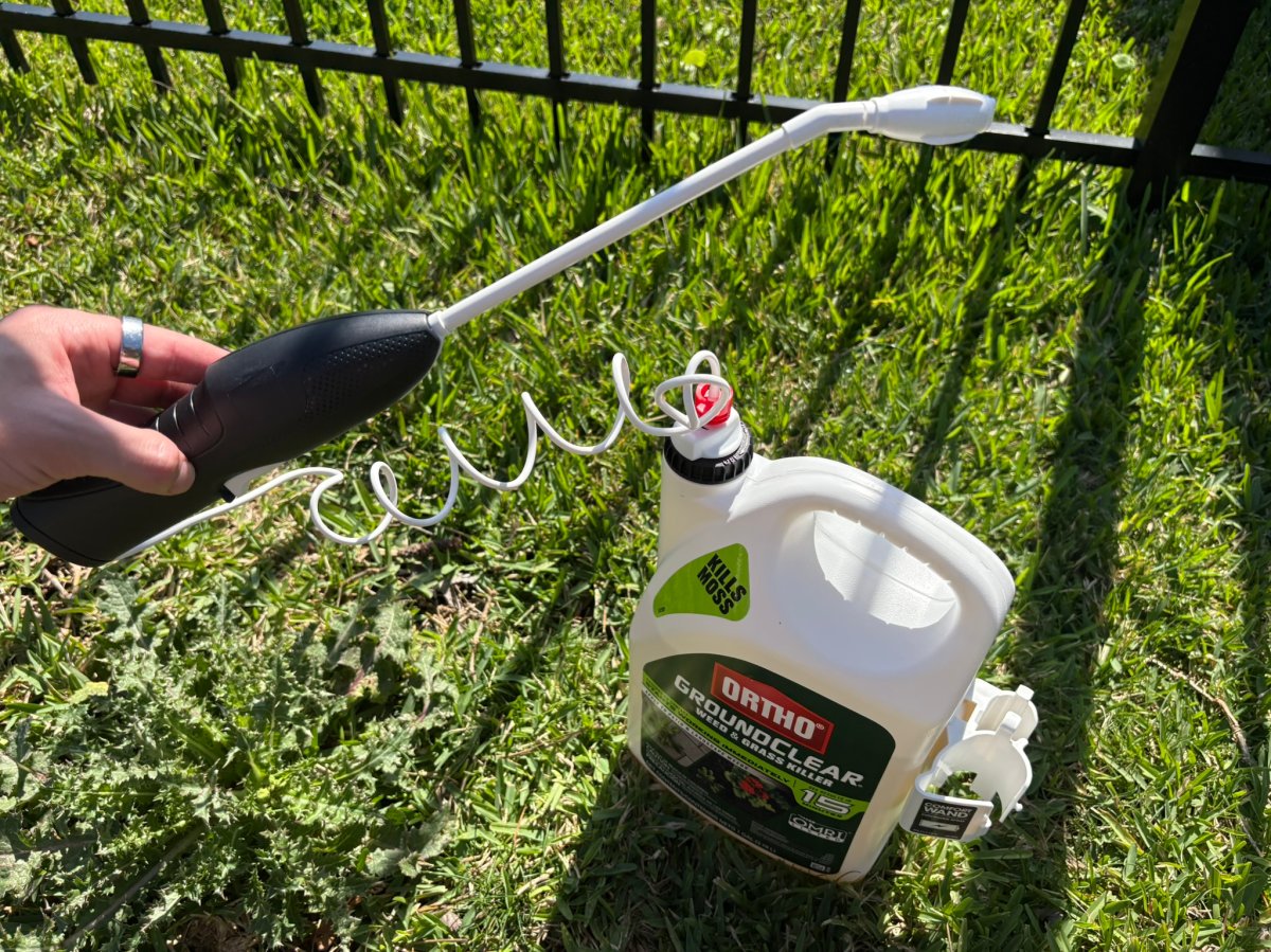 A product tester holding the spray wand of the Ortho GroundClear weed killer 