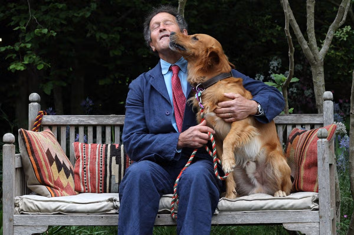 Gardener Monty Don poses with his dog Ned, a Golden Retriever, in his dog-friendly garden, during the preview day at the RHS Chelsea Flower show, in London, on May 19, 2025. Sweet potatoes sprouting among flowers, talking trees powered by AI and drought resistant crops, the prestigious Chelsea Flower Show is facing the future focusing on innovation and climate change adaptation. (Photo by Adrian Dennis / AFP) (Photo by ADRIAN DENNIS/AFP via Getty Images)