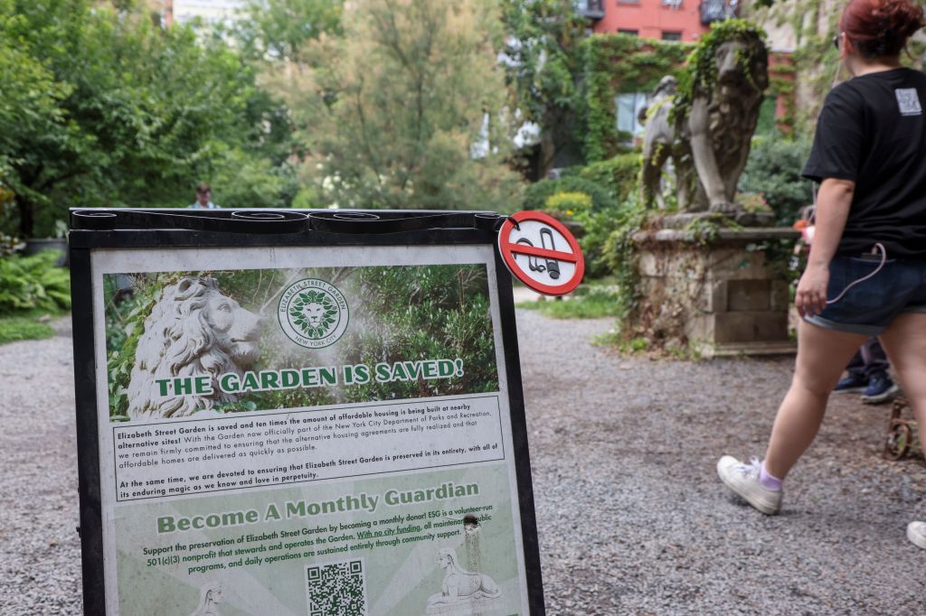 A sign at Elizabeth Street Garden declares "The Garden Is Saved!" with a no-smoking symbol attached.