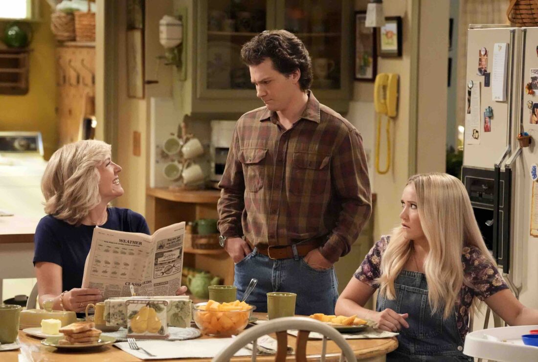 Two women and a man gather around a kitchen table