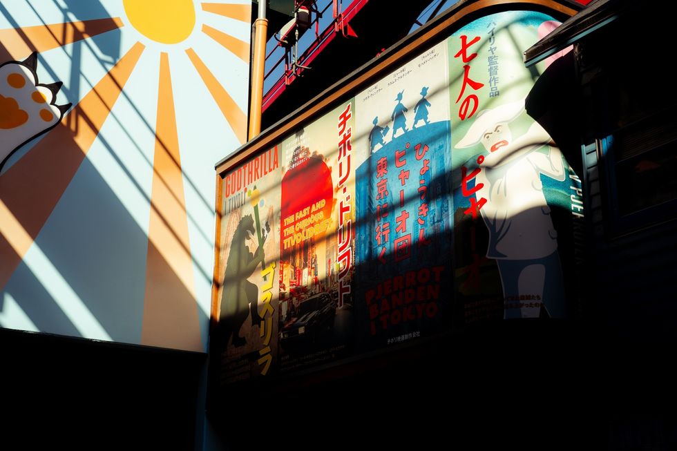 Sunlit Japanese posters with shadows in an urban setting at Tivoli Gardens