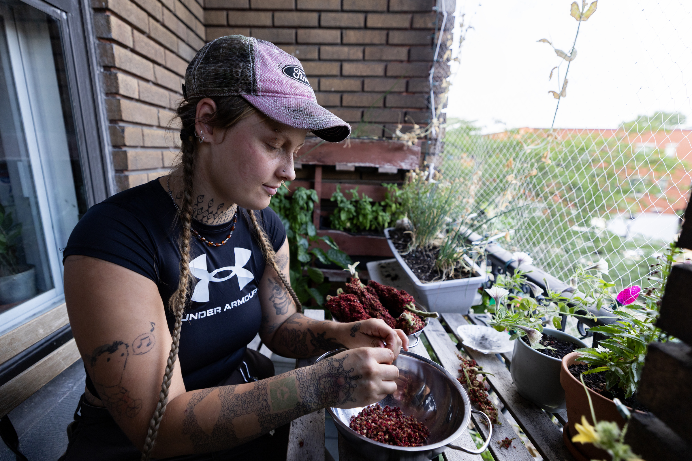 A woman works over a bowl containing food from her balcony garden