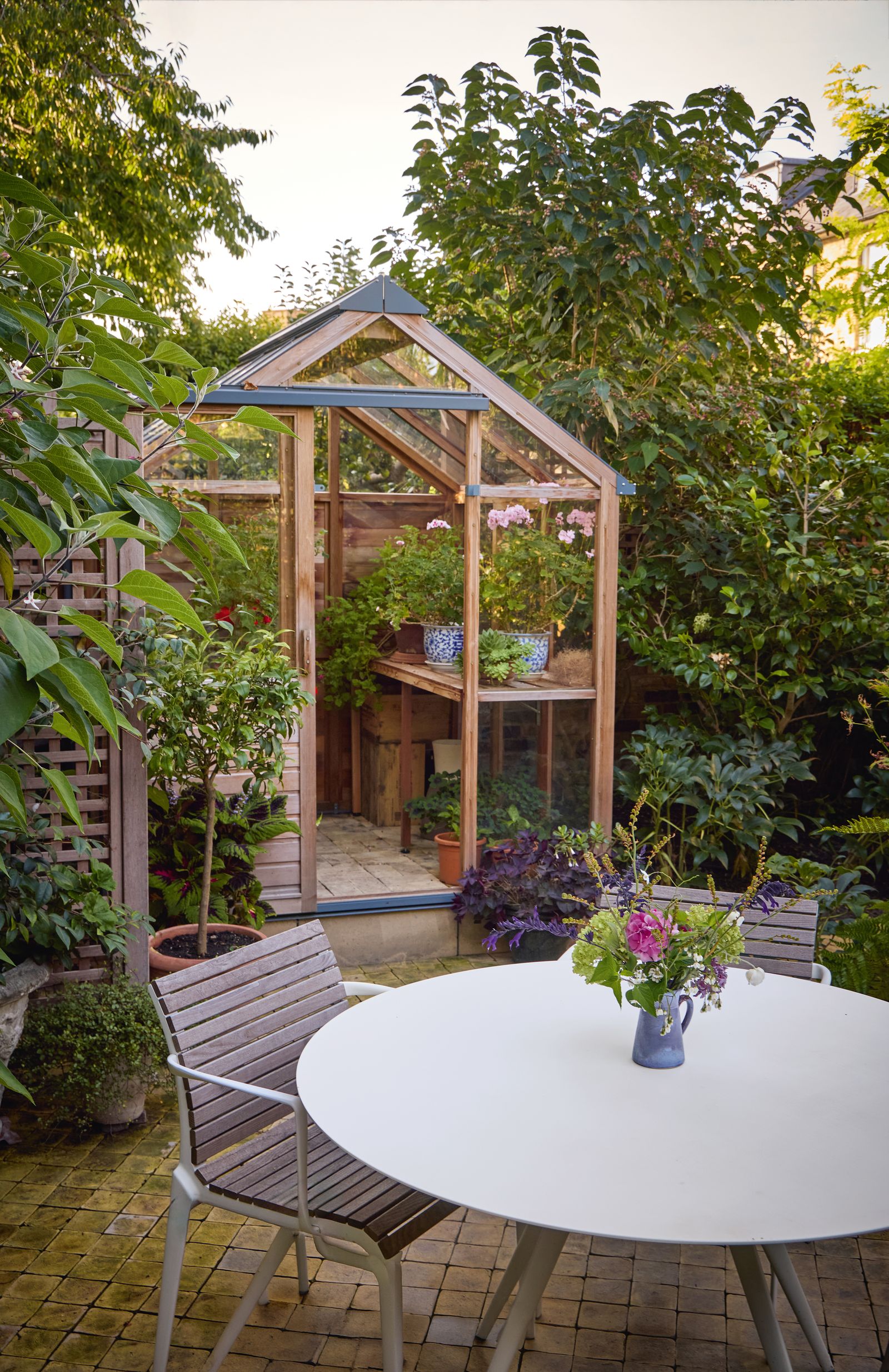 Image may contain Garden Nature Outdoors Indoors Interior Design Plant Potted Plant Backyard Yard Arbour and Chair