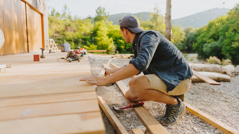 A man building a wooden deck.