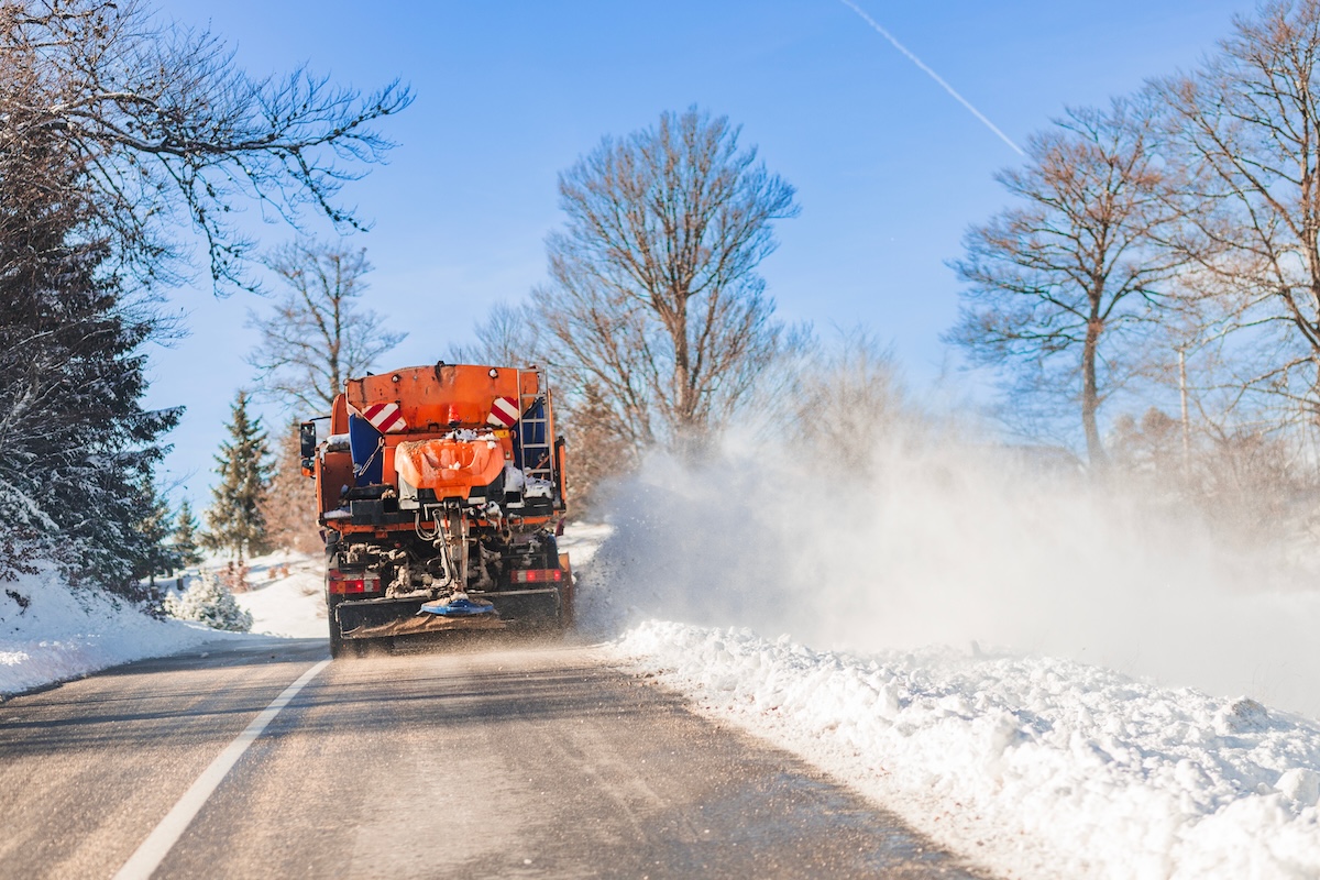 A salt truck on the road, spraying salt